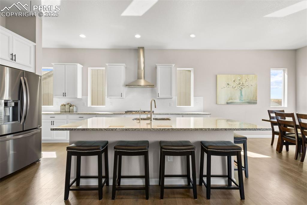 Image 7 of 47: Kitchen with appliances with stainless steel finishes, a breakfast bar, a c