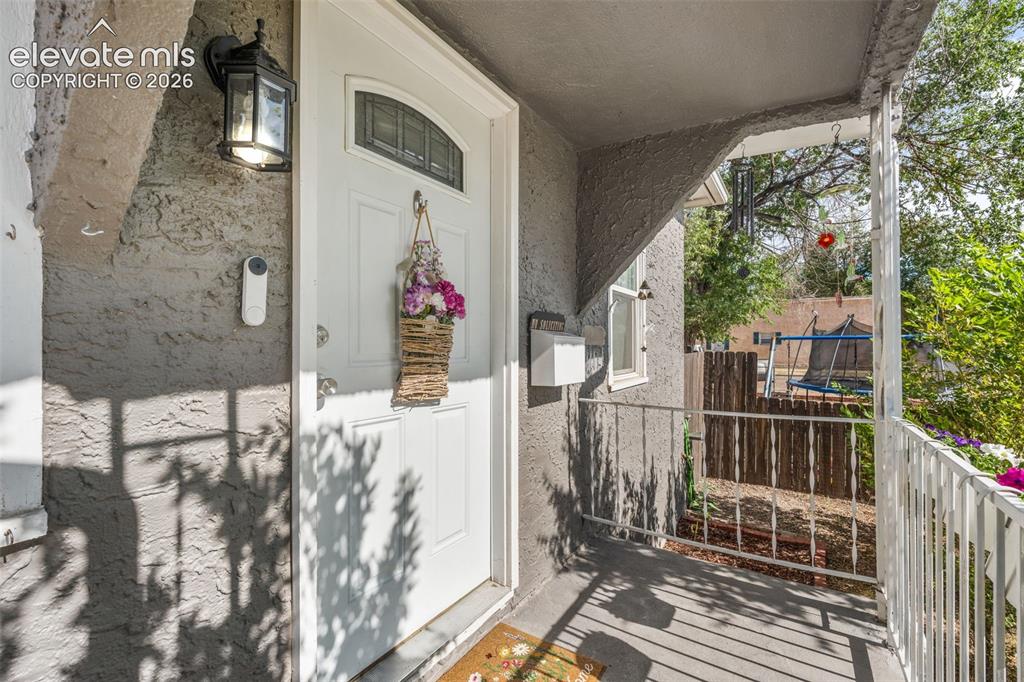 Image 10 of 50: Front entry featuring a white door with an arched window insert, stucco ext