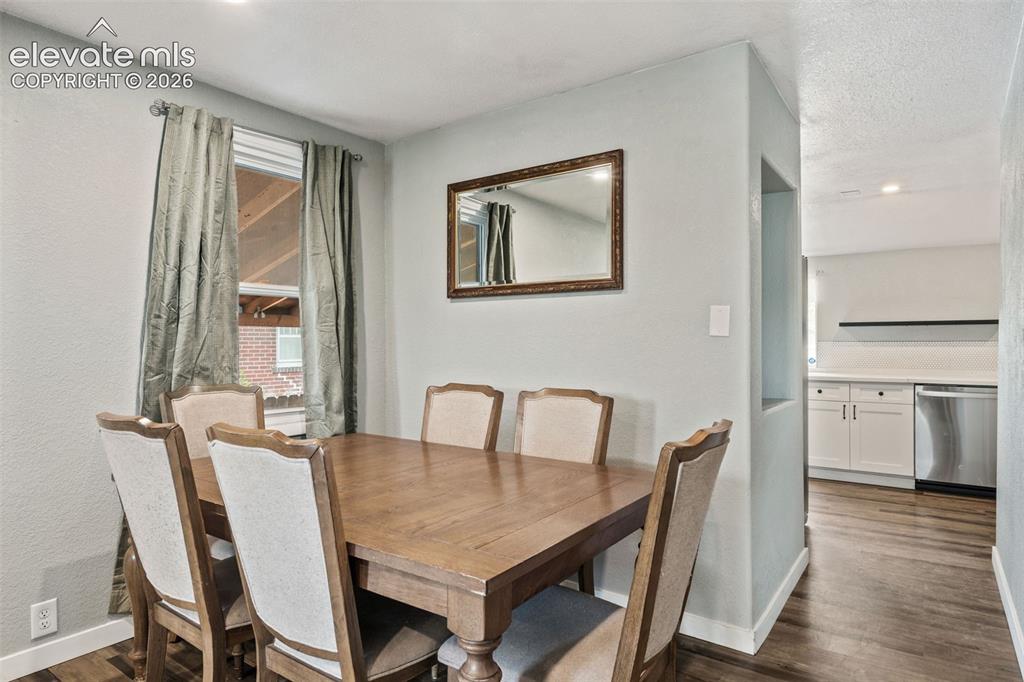 Image 13 of 50: Dining area featuring wood-finish flooring, a rectangular window with drape