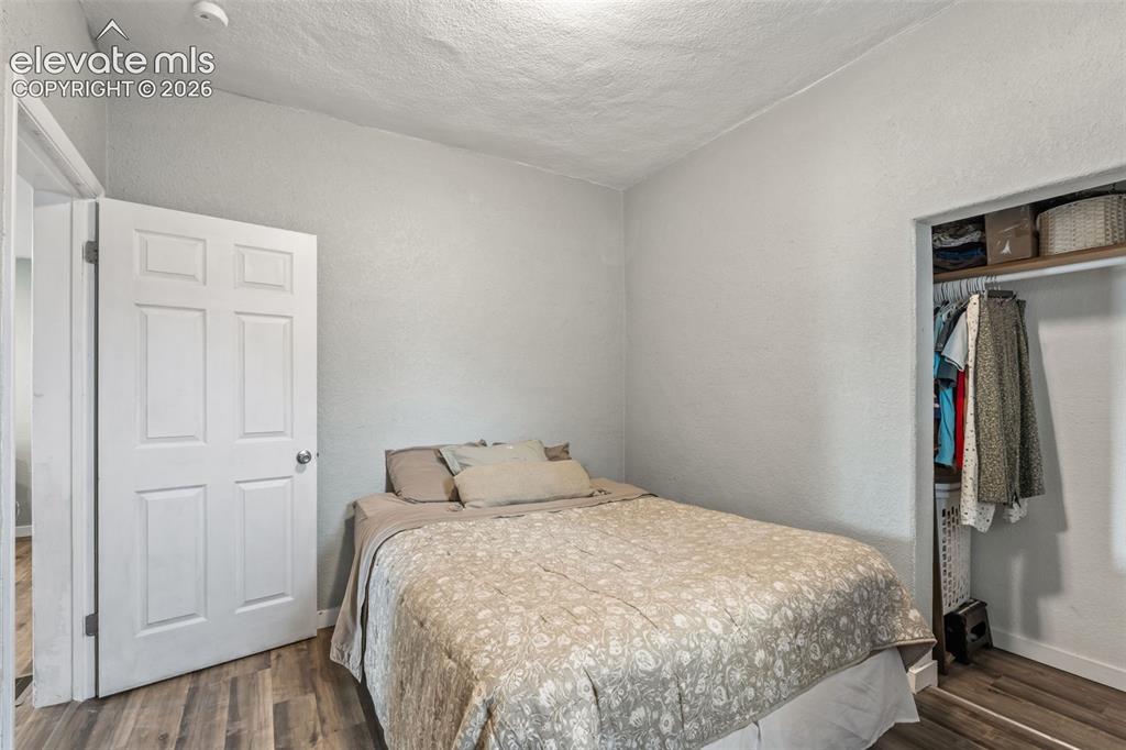 Image 23 of 50: Bedroom featuring wood-finish flooring, a six-panel interior door, and an o