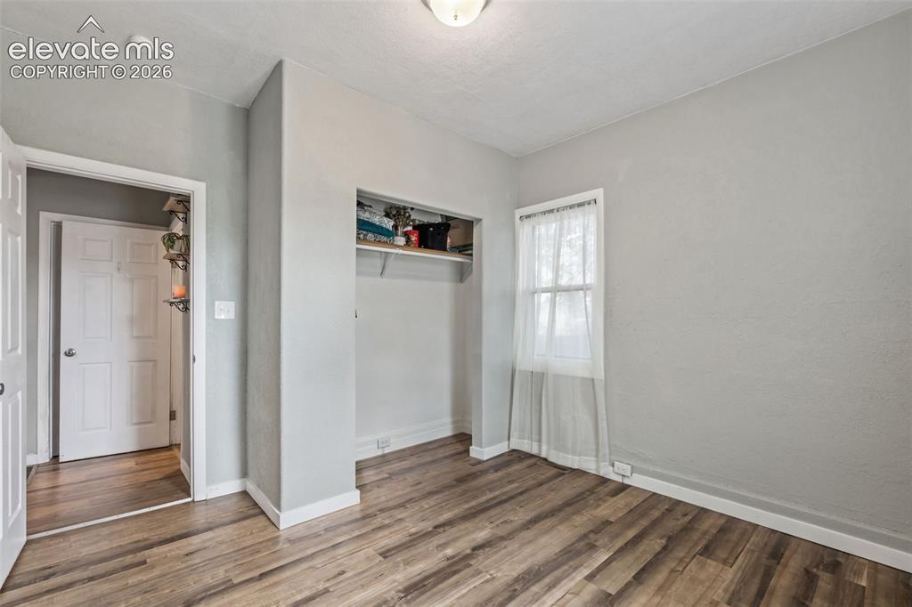 Image 27 of 50: Room featuring wood-finish flooring, light grey painted walls, white trim,