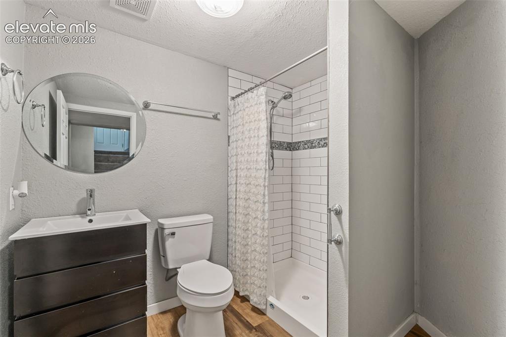 Image 36 of 50: Bathroom featuring a built-in shower with white subway tile, a decorative t