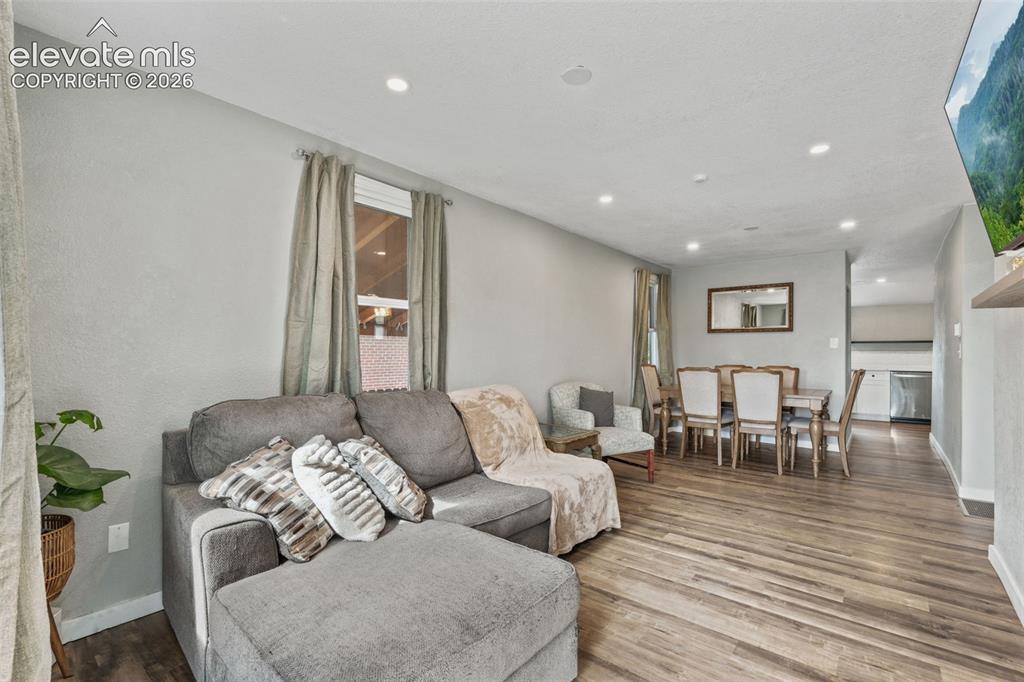 Image 6 of 50: Open-concept living space featuring recessed lighting, wood-finish flooring