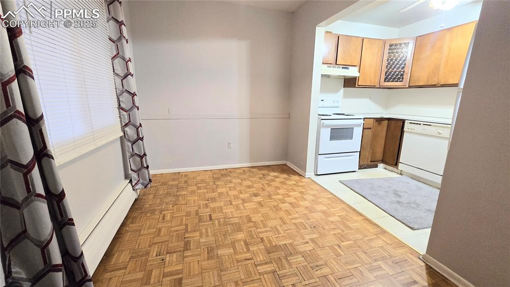 Image 9 of 18: Dining and Kitchen with light countertops, white appliances, brown cabinets