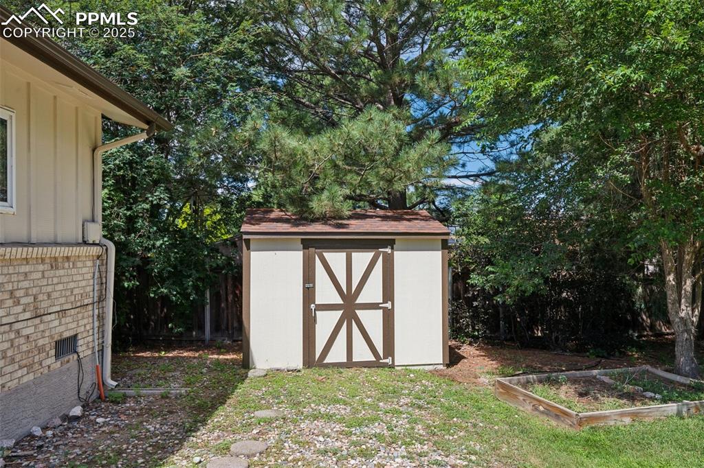 Image 10 of 34: View of shed with a garden
