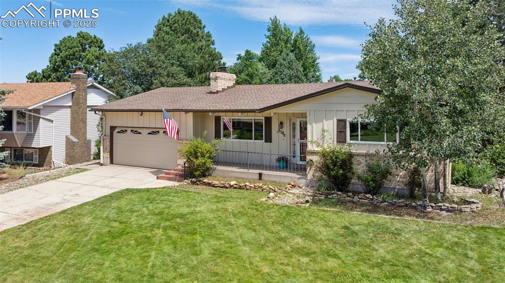 Image 2 of 34: Ranch-style home featuring board and batten siding, a garage, driveway, and