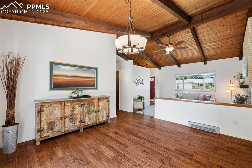 Image 22 of 34: Dining room with a wood ceiling with exposed beams, wood-type flooring, cei