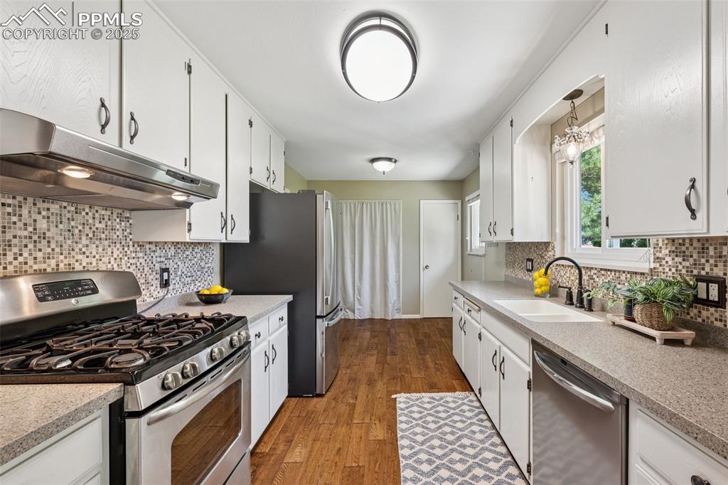 Image 25 of 34: Kitchen featuring appliances with stainless steel finishes, under cabinet r