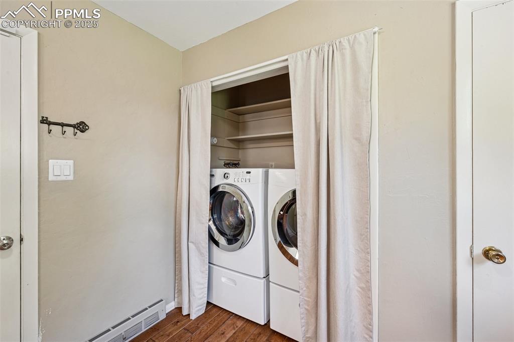 Image 27 of 34: Laundry room with dark wood finished floors, washer and clothes dryer