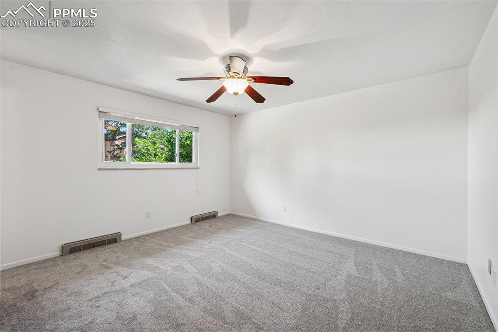 Image 28 of 34: Primary bedroom featuring carpet floors and ceiling fan