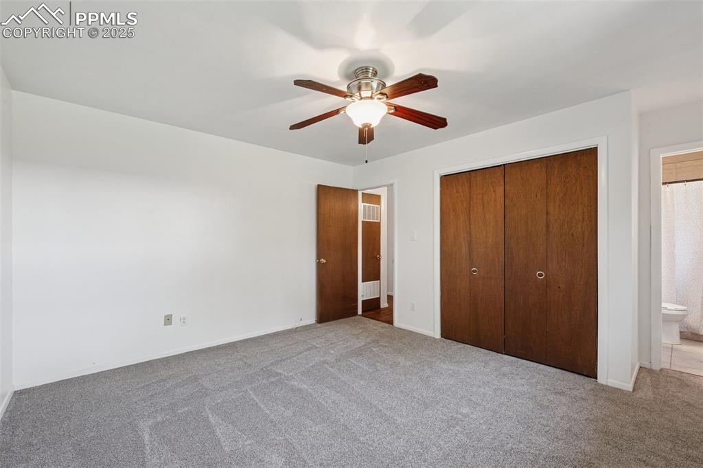 Image 29 of 34: Primary bedroom featuring carpet floors, a closet, ensuite bathroom, and a