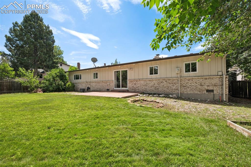 Image 6 of 34: Rear view of property featuring brick siding, a patio area, a fenced backya