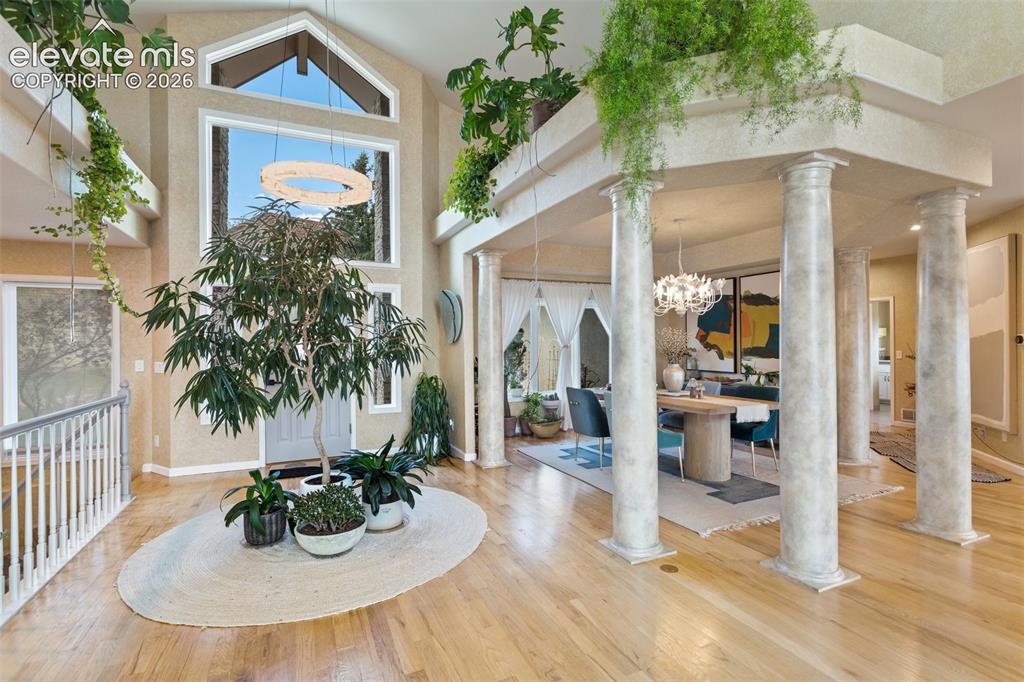 Image 12 of 50: Grand entry foyer featuring light wood-finish flooring, a soaring vaulted c