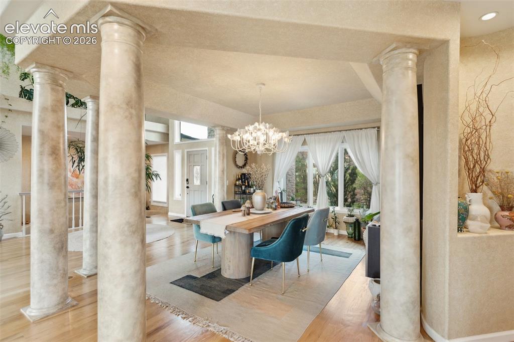 Image 13 of 50: Dining area featuring a crystal chandelier, wood-finish flooring, and a lar