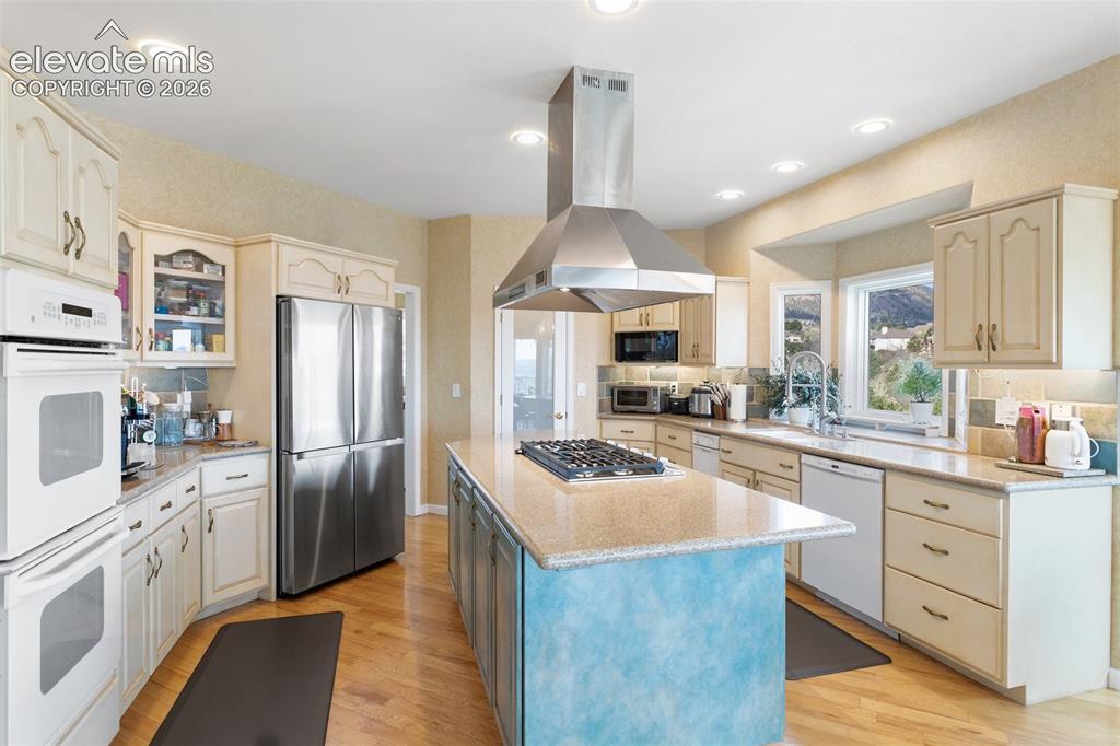 Image 16 of 50: Spacious kitchen featuring an expansive central island with a built-in cook