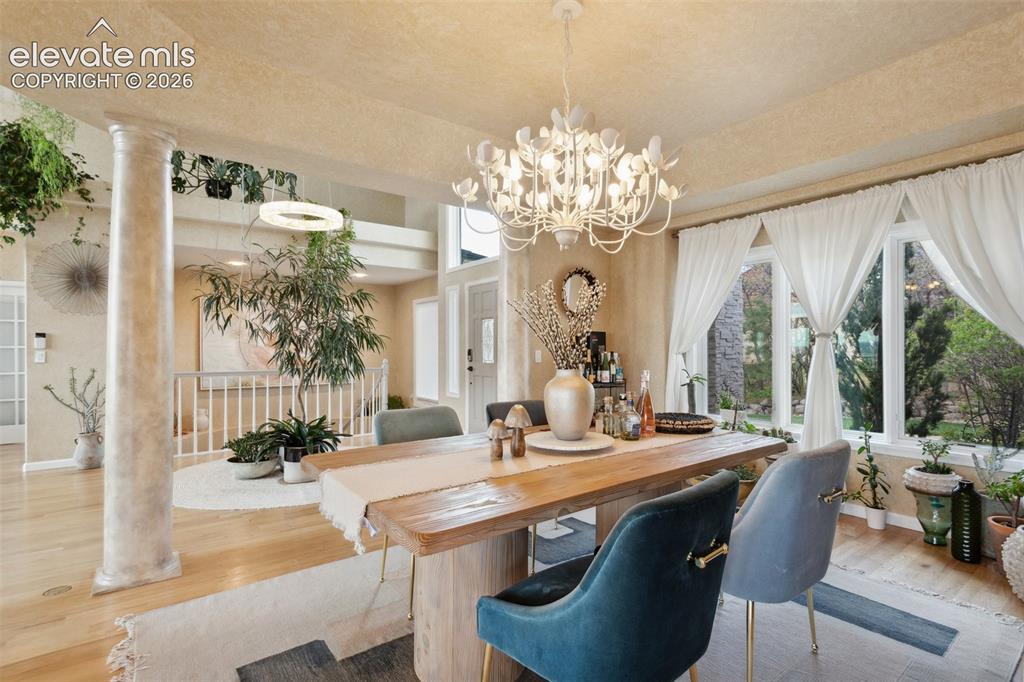Image 18 of 50: Dining area featuring a substantial wood table and a distinctive chandelier