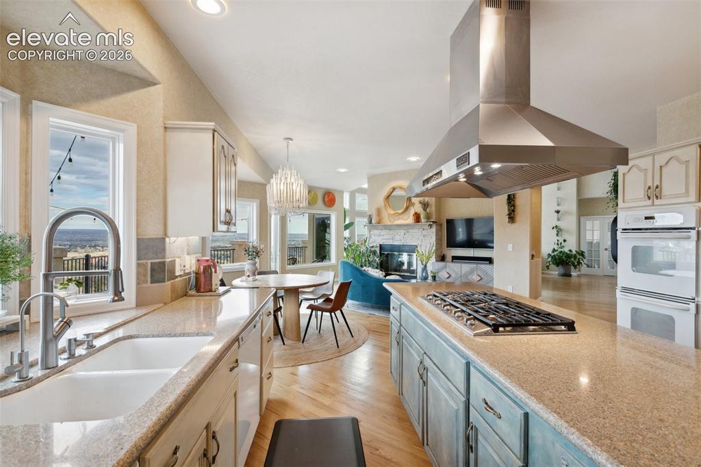 Image 21 of 50: Open-concept kitchen featuring a large island with a built-in gas cooktop a
