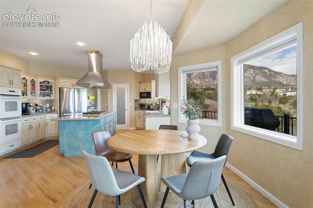 Image 25 of 50: Open-concept kitchen and dining area featuring light wood-finish flooring,