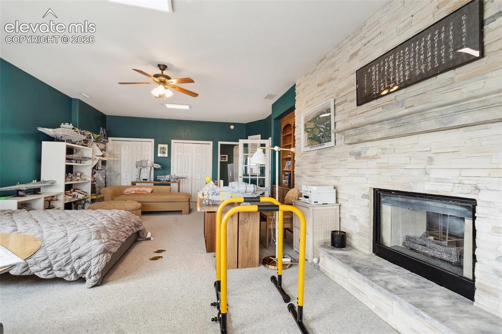 Image 28 of 50: Living area featuring a floor-to-ceiling stacked stone fireplace, a ceiling