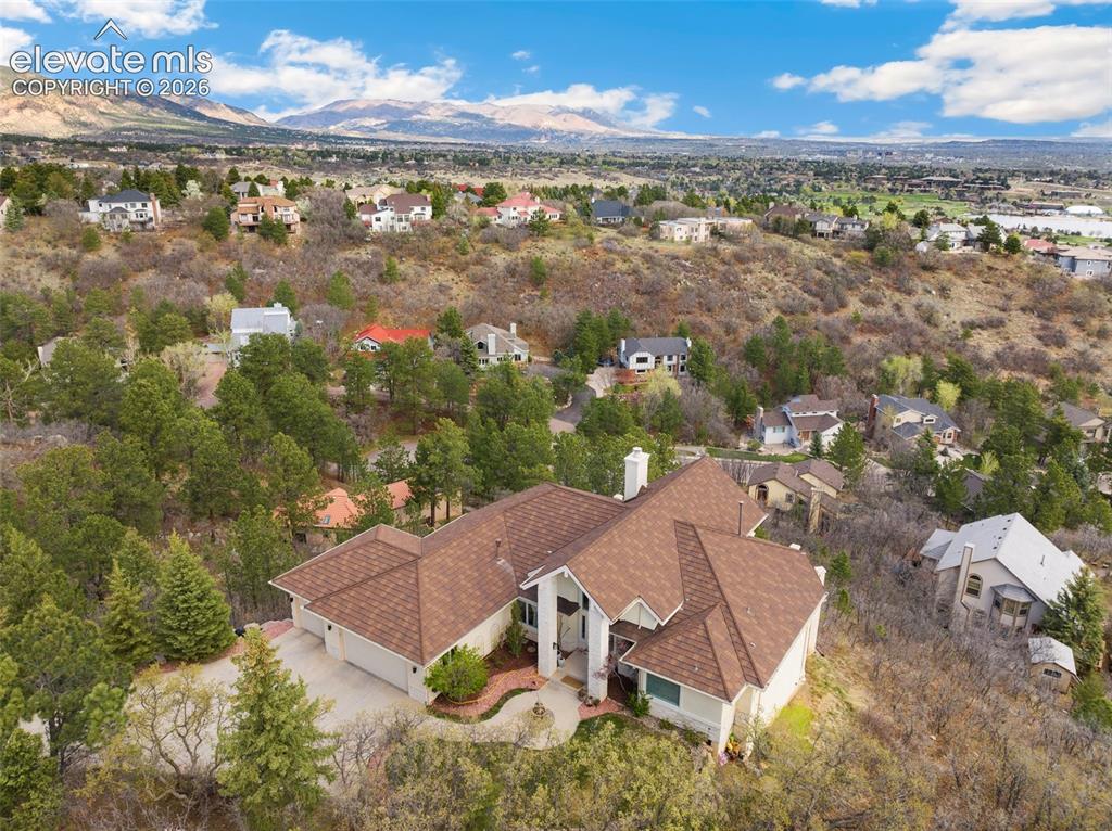 Image 3 of 50: Hillside residence featuring a multi-gabled roof, light-toned exterior, and