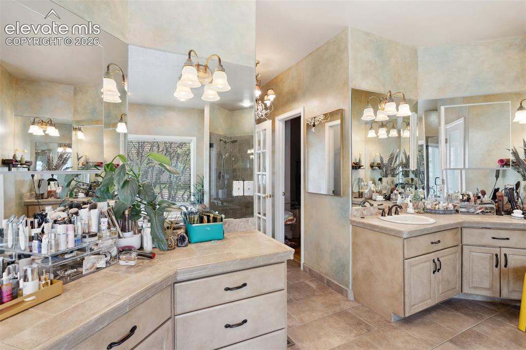 Image 30 of 50: Spacious bathroom featuring double vanity with integrated sink, ample count