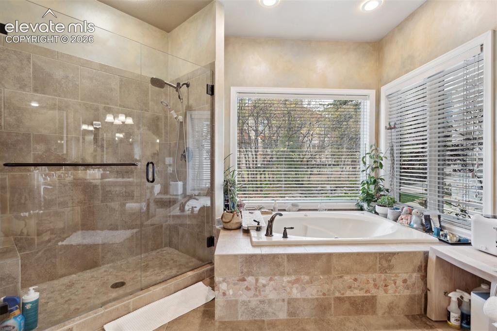 Image 31 of 50: Spacious bathroom featuring an oversized soaking tub with surrounding windo