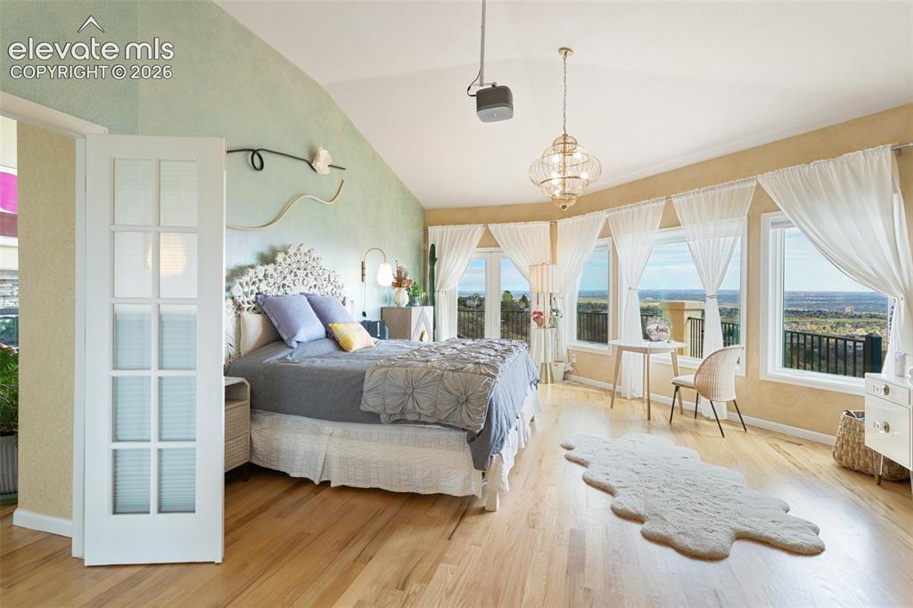 Image 33 of 50: Spacious bedroom featuring light wood-finish flooring, a vaulted ceiling, a