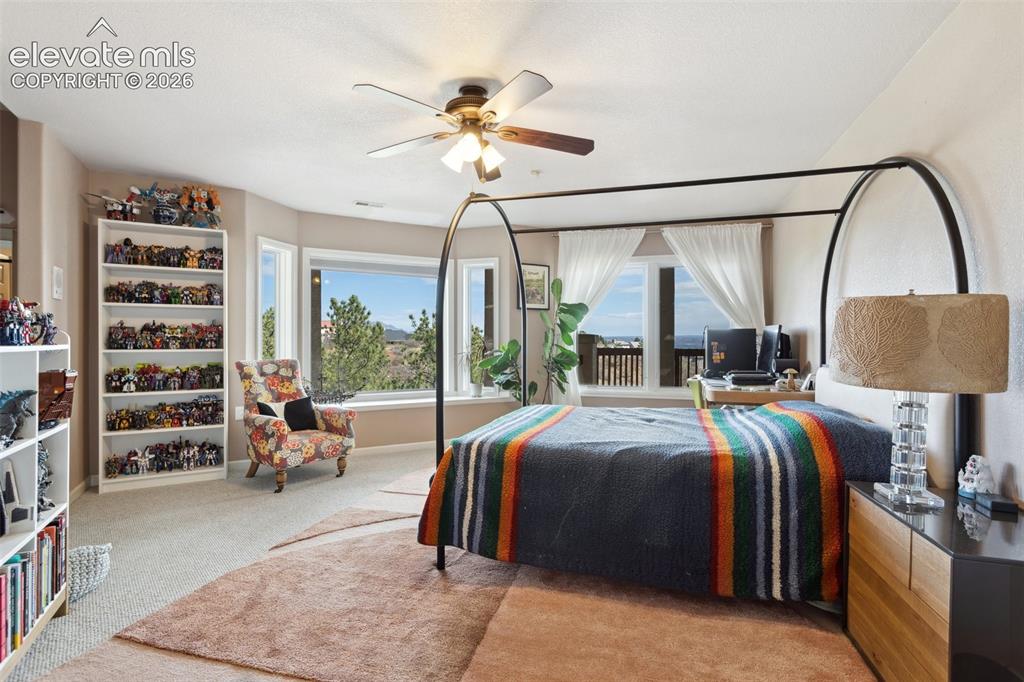 Image 35 of 50: Spacious room featuring broad picture windows, soft neutral carpeting, a ce