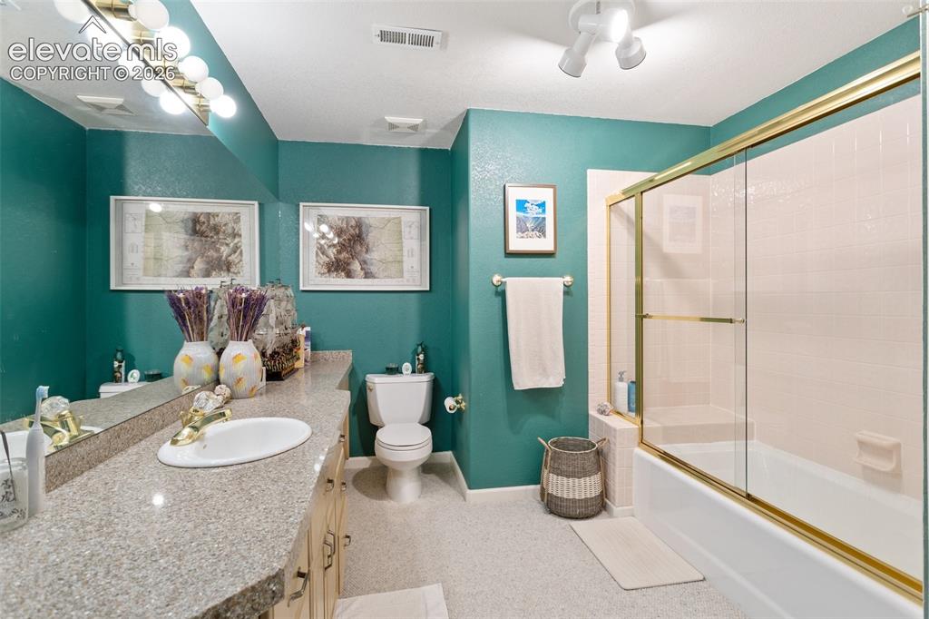 Image 38 of 50: Bathroom featuring a double vanity with an oval basin, a gold-toned faucet,