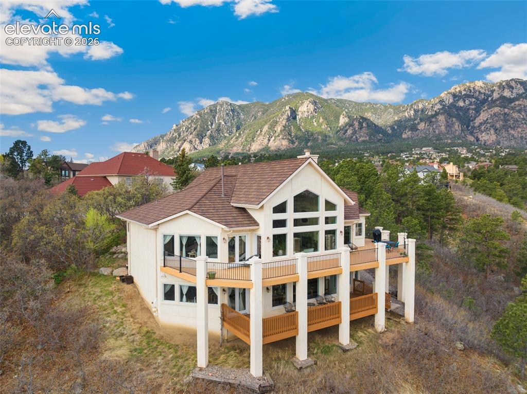 Image 4 of 50: Multi-level residence featuring a brown shingle roof, light-colored siding,