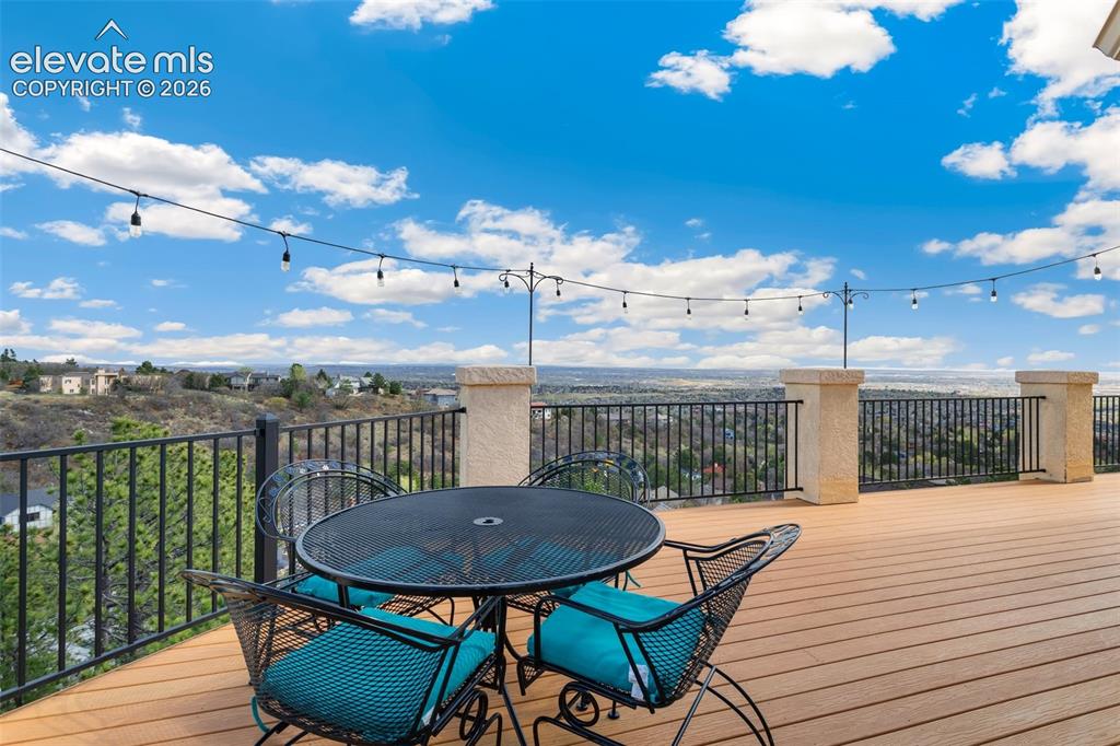 Image 46 of 50: Expansive outdoor deck featuring wood-finish decking, decorative string lig