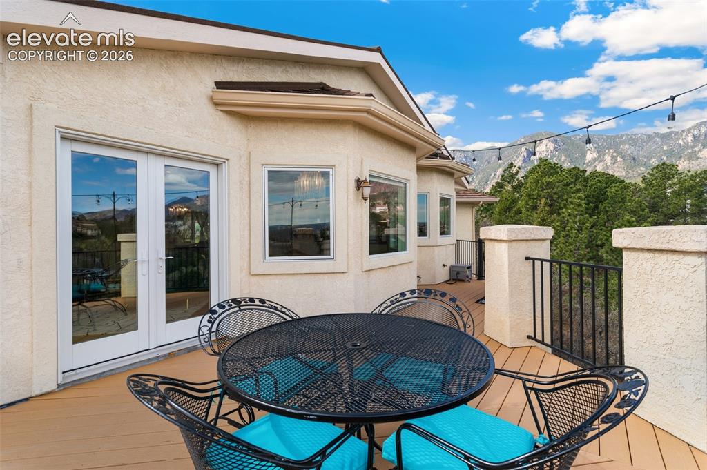 Image 48 of 50: Exterior deck featuring a mountain backdrop, stucco finish, multiple window
