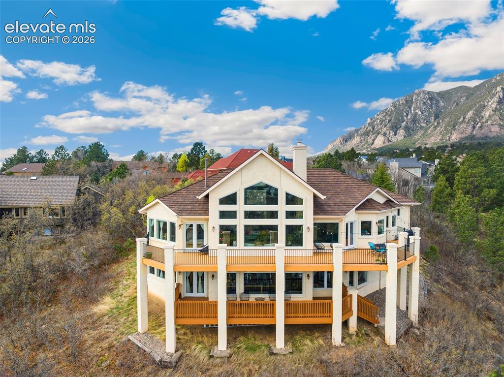 Image 5 of 50: Contemporary hillside residence featuring a multi-level deck and a prominen