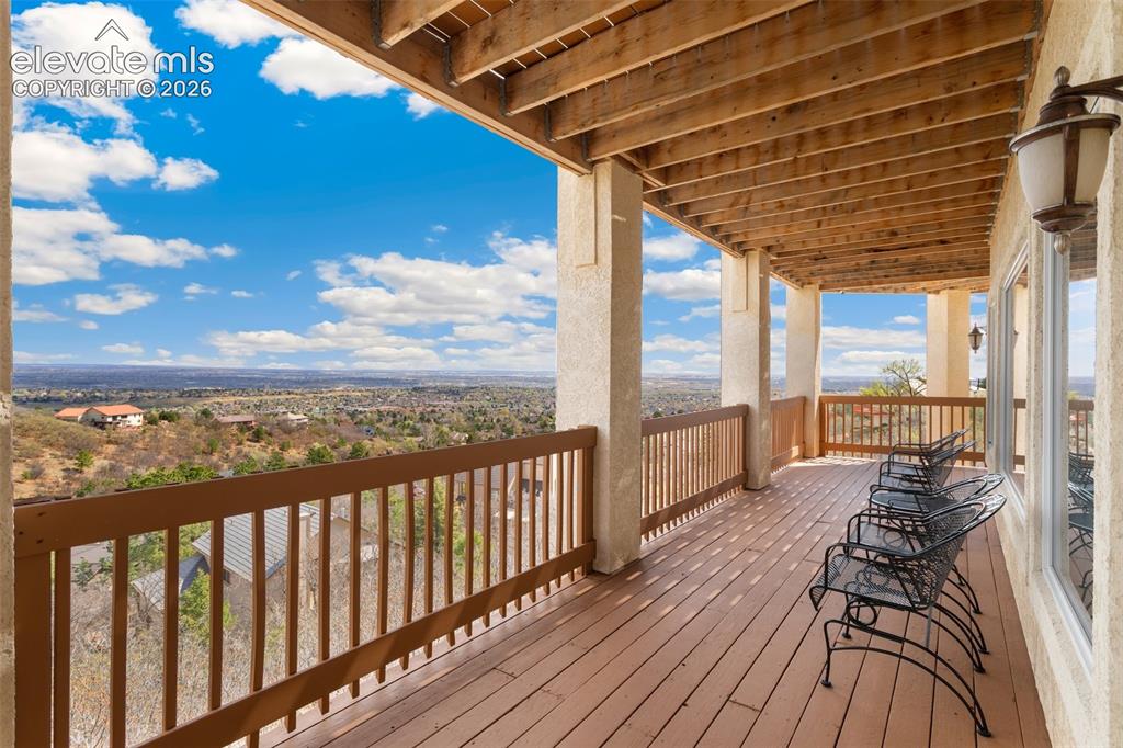 Image 50 of 50: Expansive upper-level deck featuring wood-finish flooring, a wood railing s