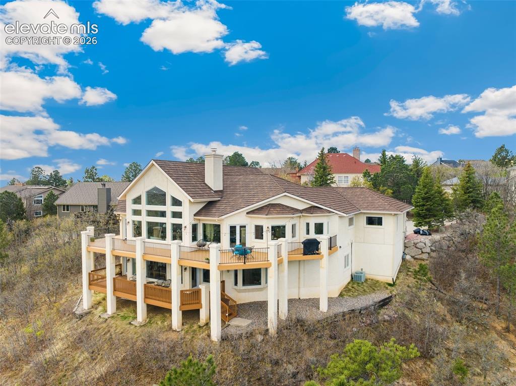 Image 6 of 50: Hillside residence featuring a multi-level deck, expansive window arrangeme
