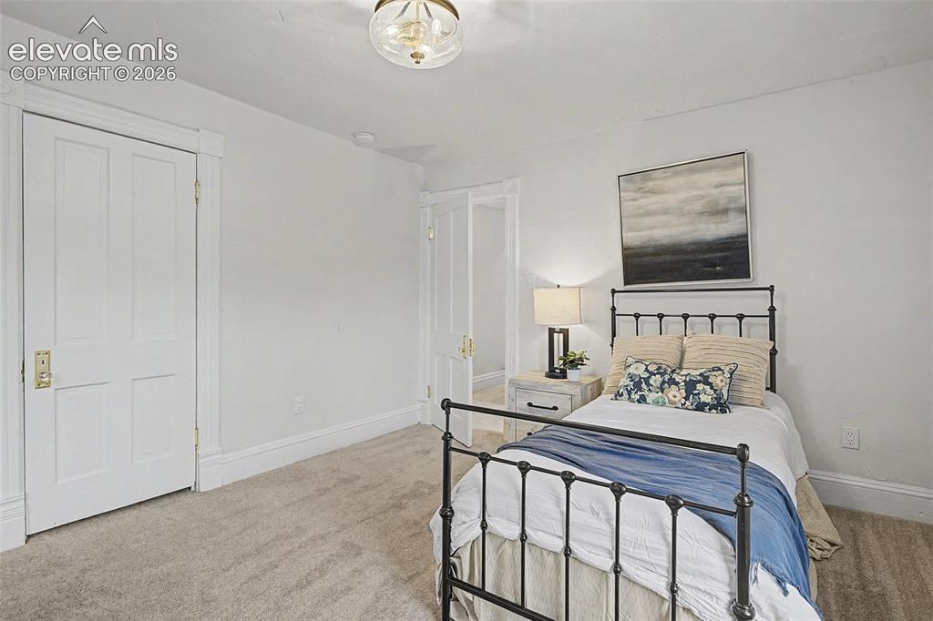Image 19 of 38: Bright interior space featuring light gray carpeting, tall white baseboards