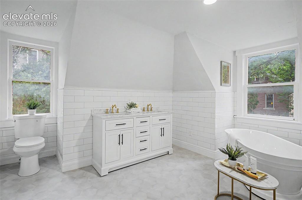 Image 25 of 38: Dual vanity featuring a white cabinet with dark hardware and a light-toned