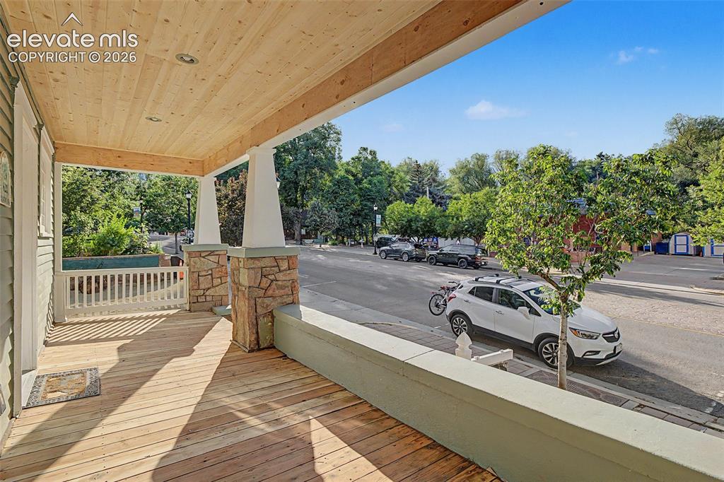 Image 3 of 38: Covered front porch featuring wood-finish flooring and a natural wood plank