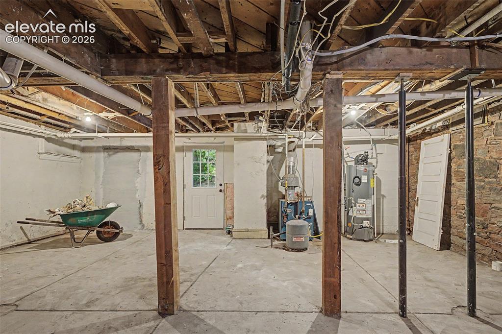 Image 38 of 38: Unfinished basement featuring exposed wood ceiling joists, concrete floorin