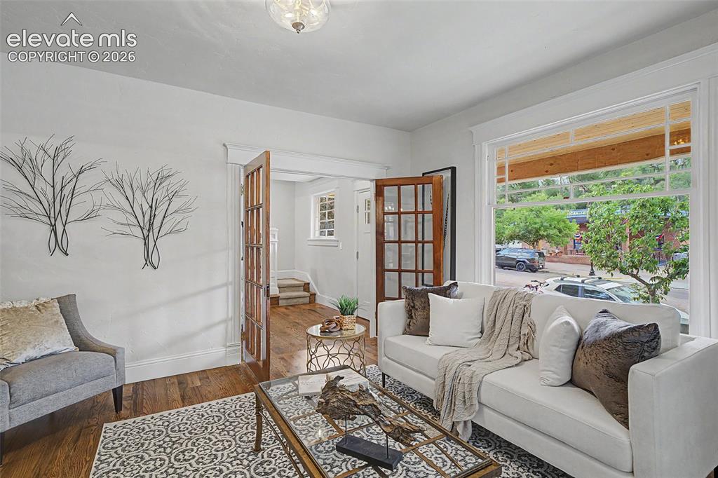Image 5 of 38: Hardwood flooring extending throughout, French doors with glass panes, deco