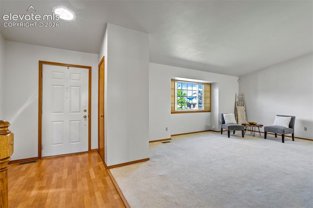 Image 9 of 50: A bright entry way and  living room welcomes you home