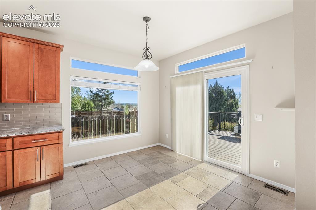 Image 10 of 37: Dining area featuring tile flooring, a large picture window, and a sliding 