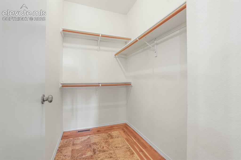 Image 14 of 37: Walk-in closet featuring white walls, wood-finish flooring, and built-in sh