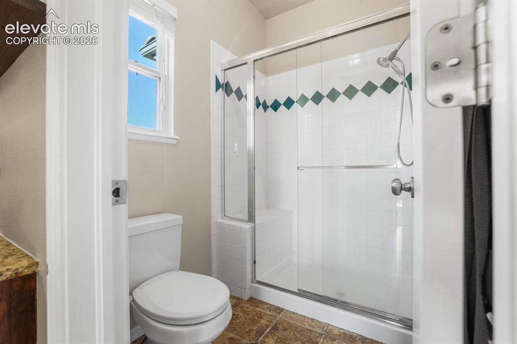 Image 15 of 37: Full bathroom featuring a glass-enclosed shower with a built-in bench, whit