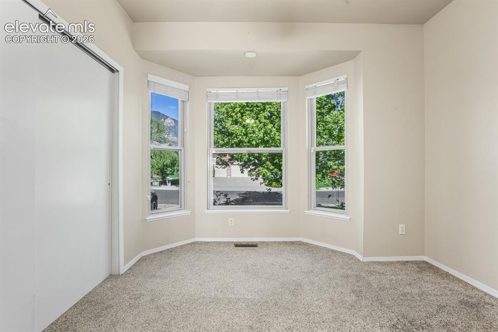 Image 17 of 37: Bay window with three large panes, neutral tone carpeting, light-colored wa