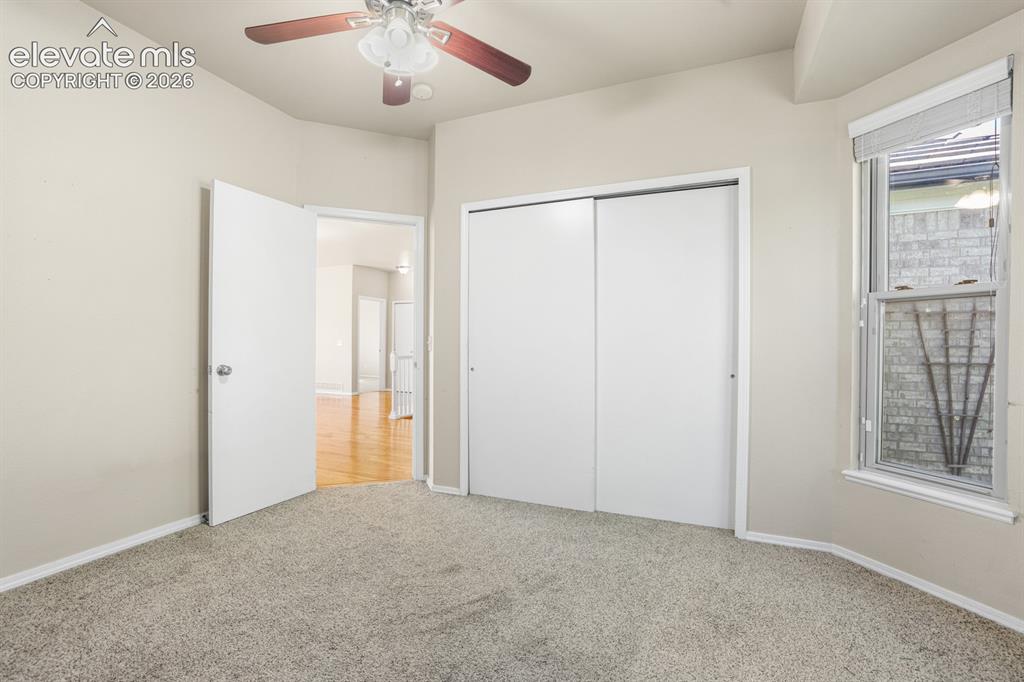 Image 18 of 37: Carpeted interior room featuring a ceiling fan with light fixture, double s