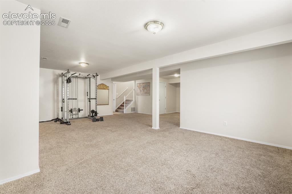 Image 20 of 37: Spacious open room featuring neutral carpeting and white wall finishes