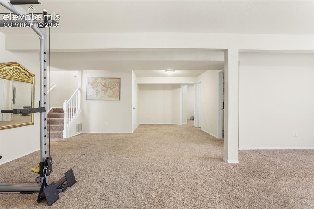Image 21 of 37: Spacious finished basement featuring neutral carpeting throughout