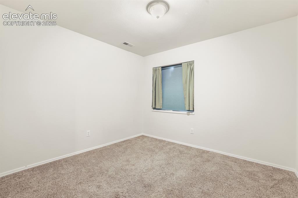 Image 23 of 37: Room featuring neutral-toned carpeting, light-colored walls, and a window w