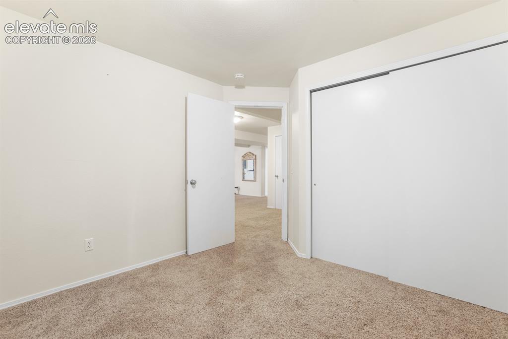 Image 24 of 37: Interior room featuring neutral-toned carpet and white walls
